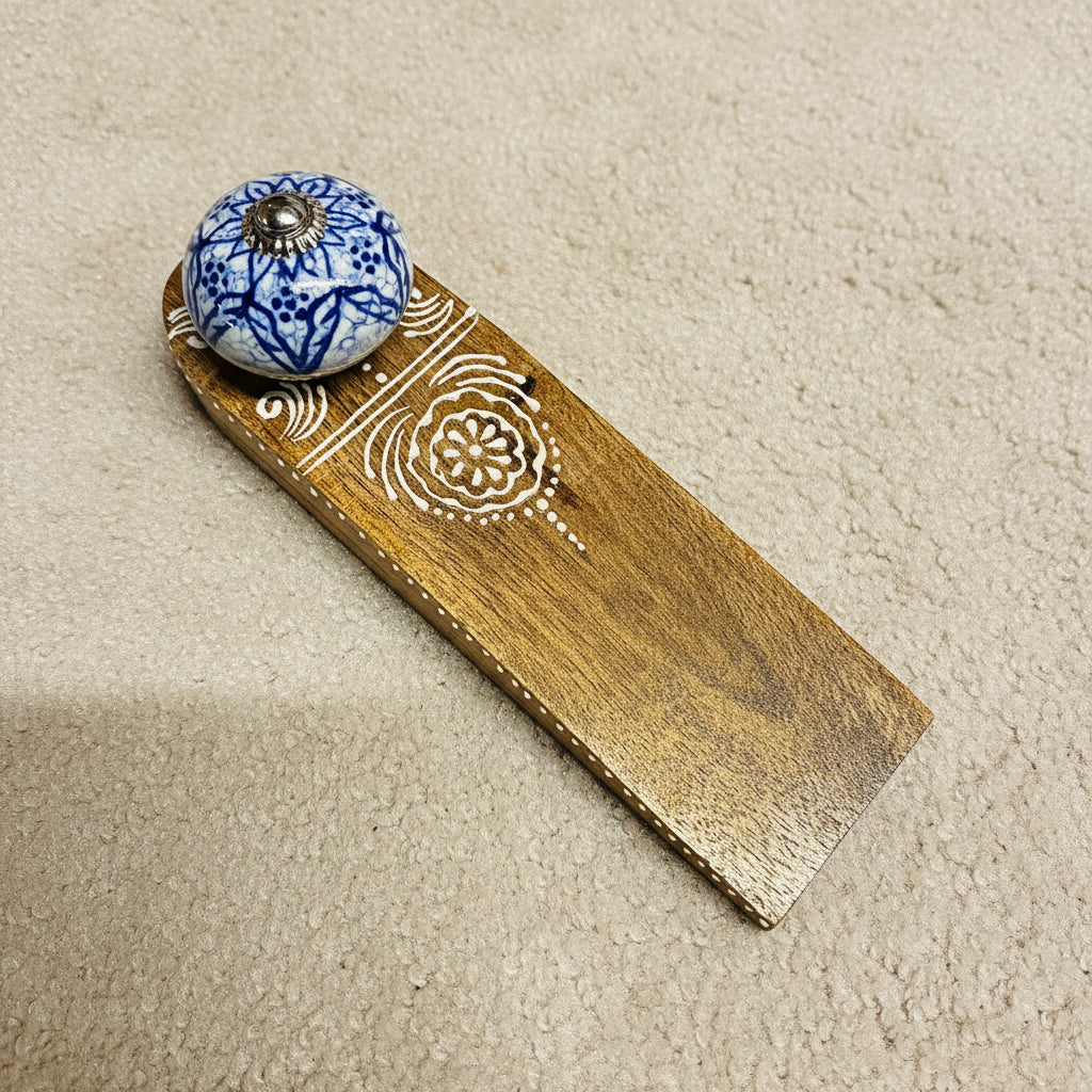 Decorative wooden item with a blue and white ceramic knob on a dark surface