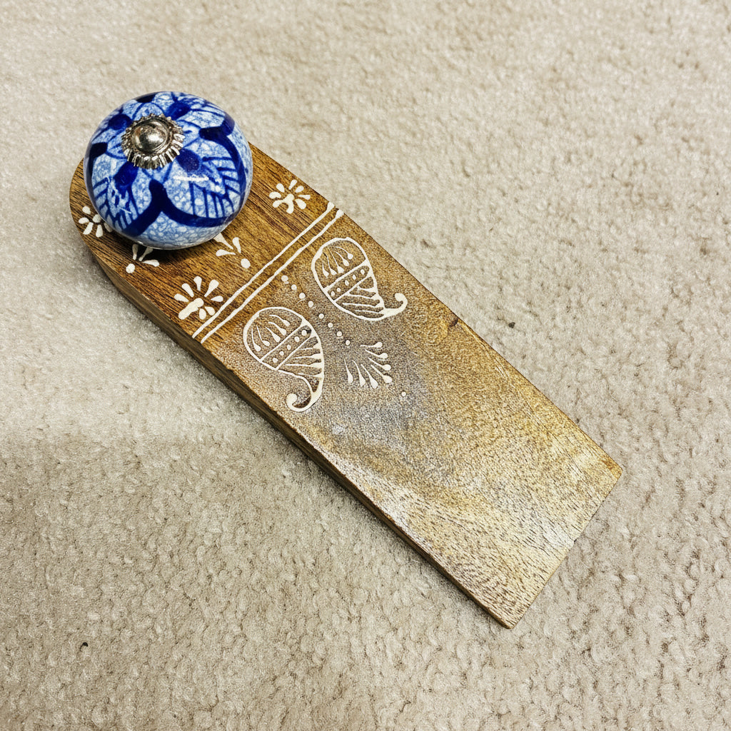 Wooden bookmark with decorative blue knob on a dark surface