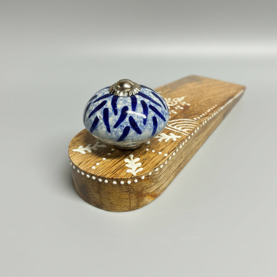 Decorative wooden knob with blue floral pattern on a dark gray background