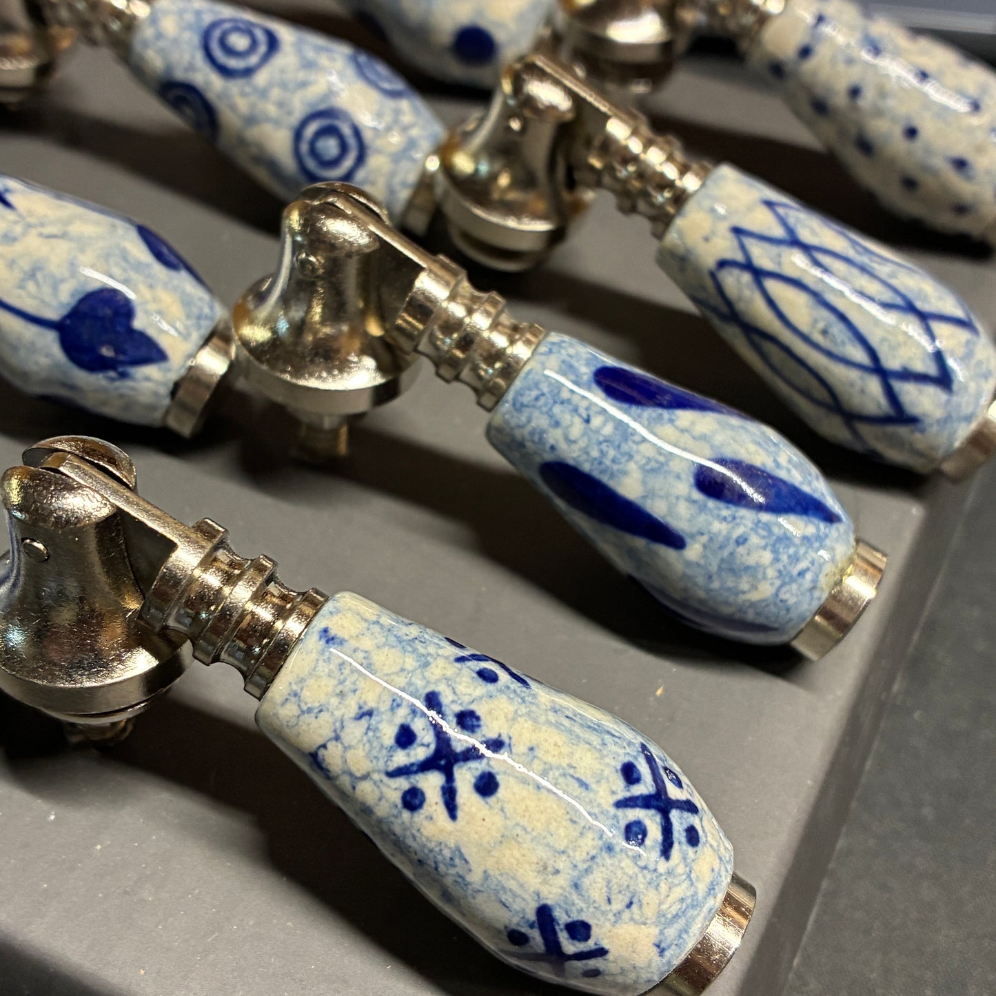 Close-up of ceramic bottle stoppers with blue patterns on a gray surface