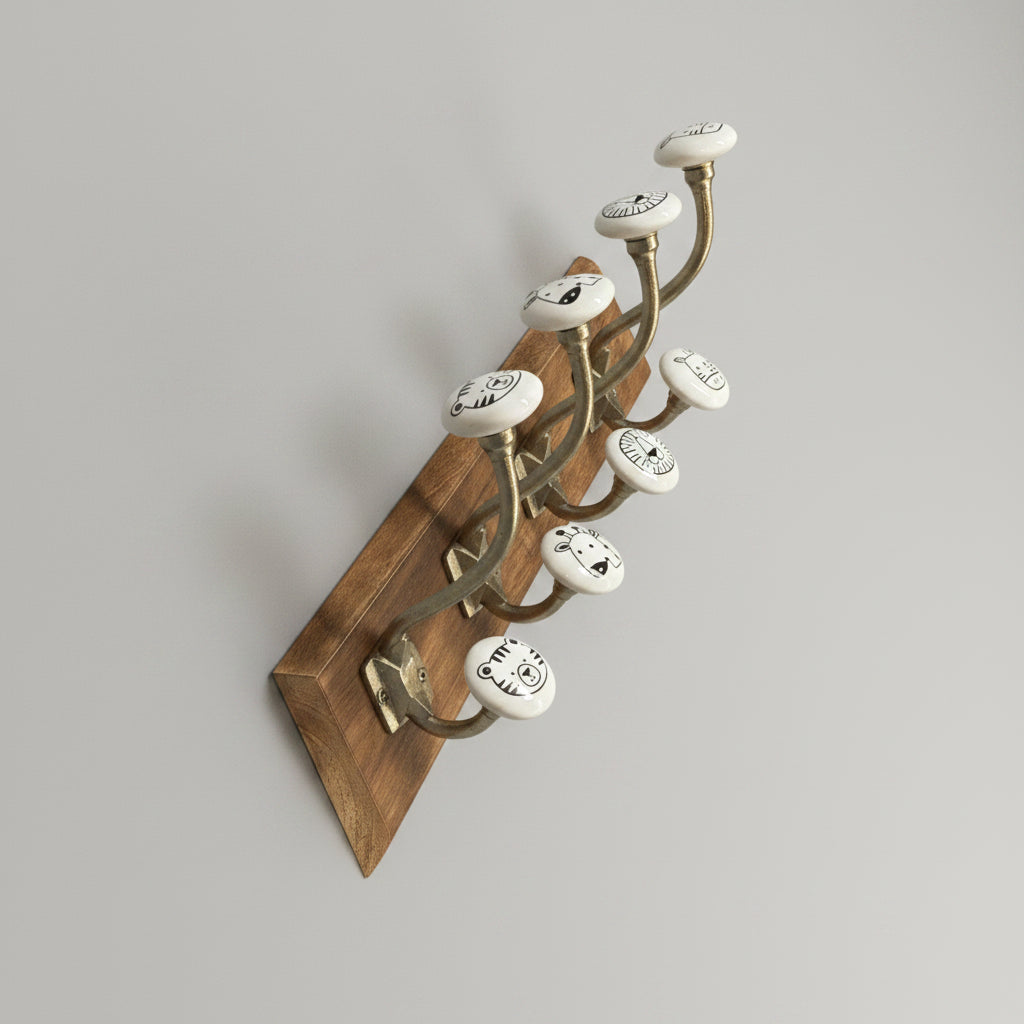 Wooden hook with cat-shaped hooks on a gray floor next to a cardboard box.
