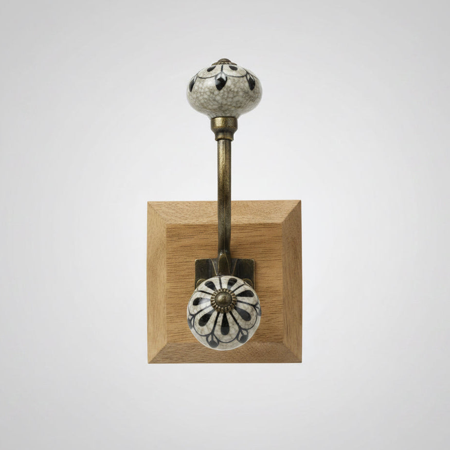 Decorative doorknob on a wooden stand held by a hand with a blurred background