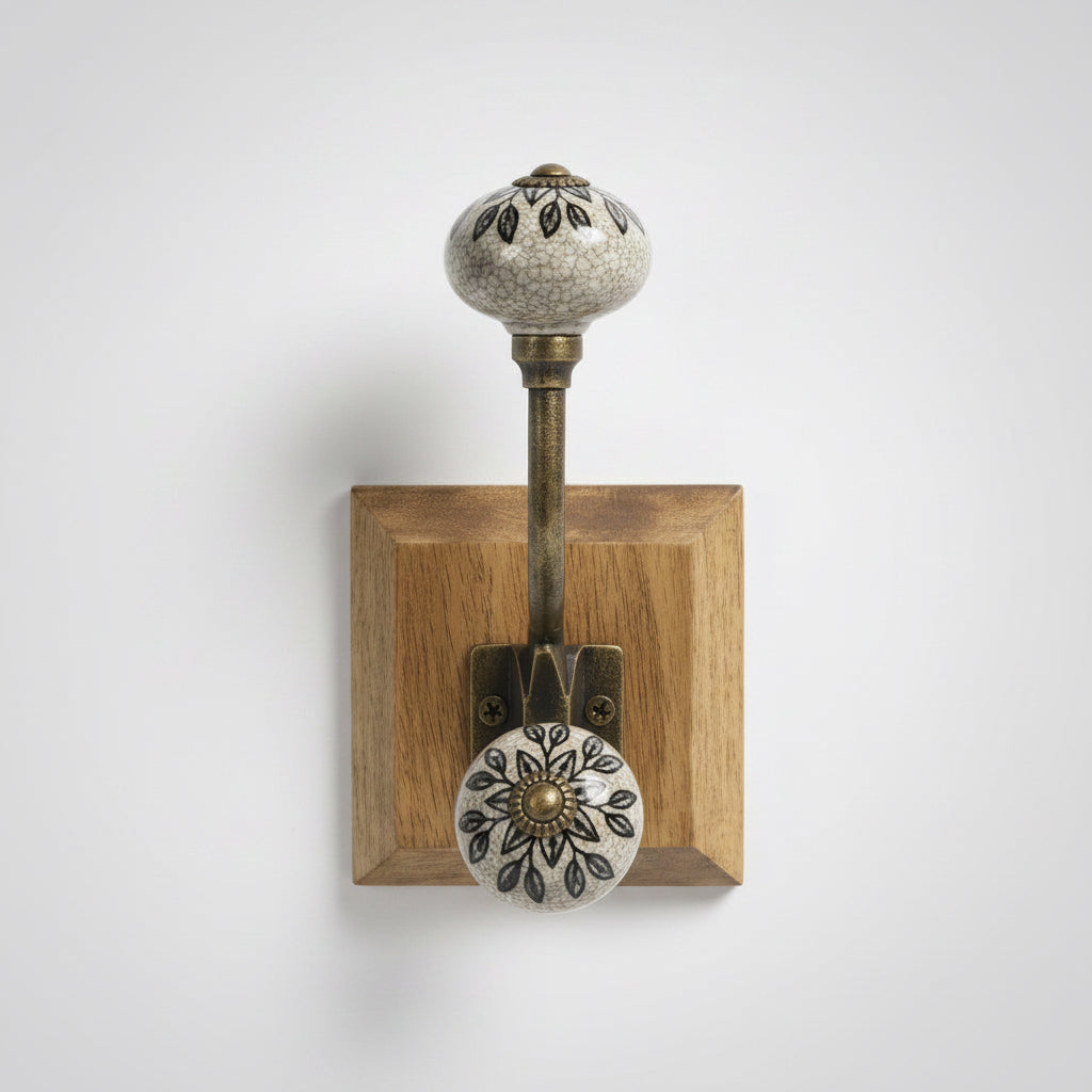 Decorative wall hook with intricate design held by a hand, with 'SiL' packaging in the background.