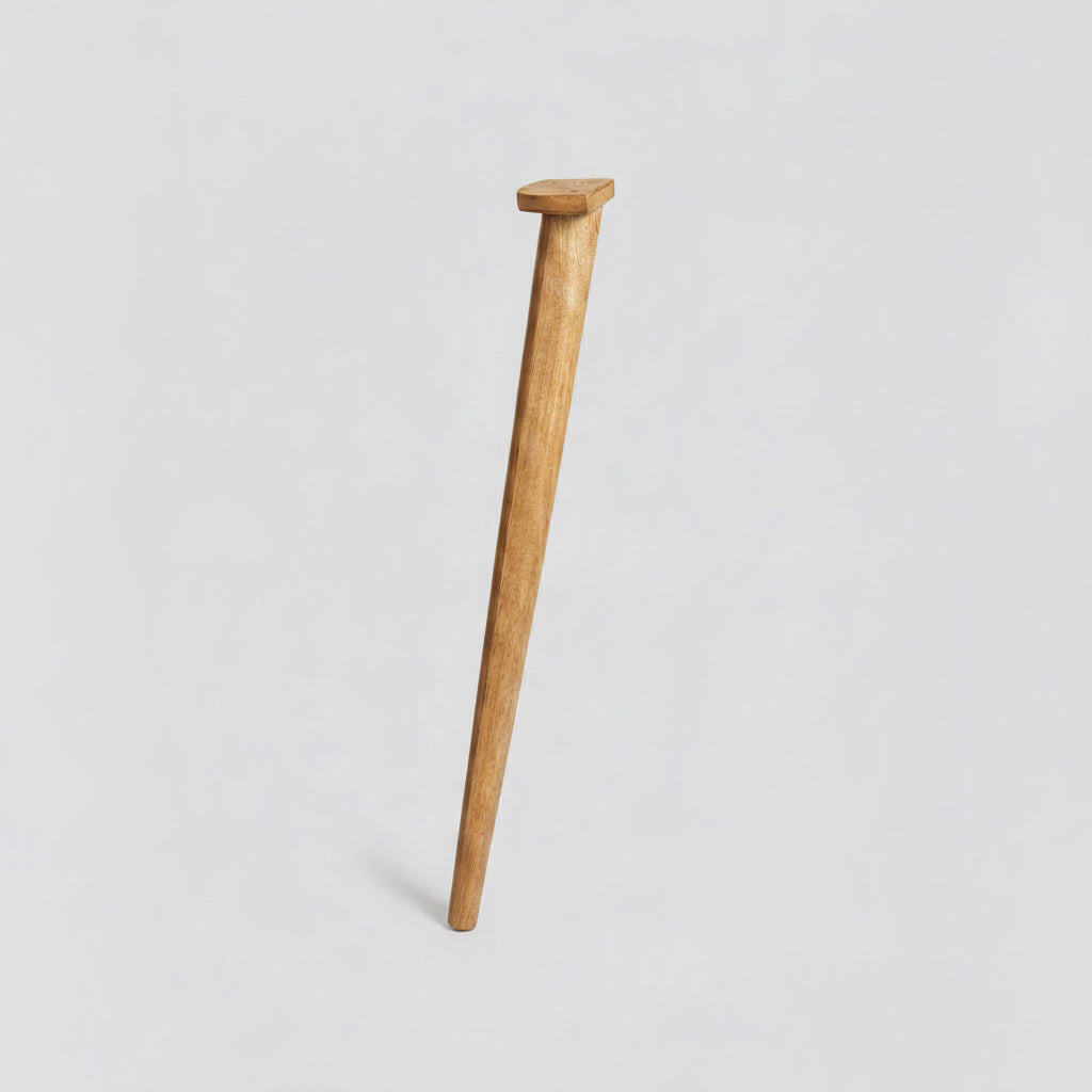 Wooden spindle on a concrete floor with cardboard boxes in the background