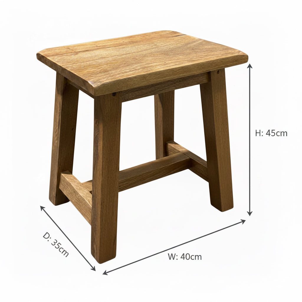 A rustic wooden stool with a thick, square slatted seat and a simple wooden frame, photographed on a gray concrete floor.