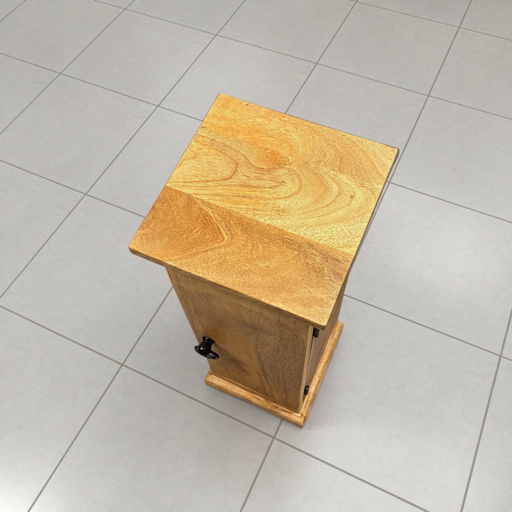 A small handmade wooden box with a slanted top and a small black latch on the front, photographed on a gray concrete floor.