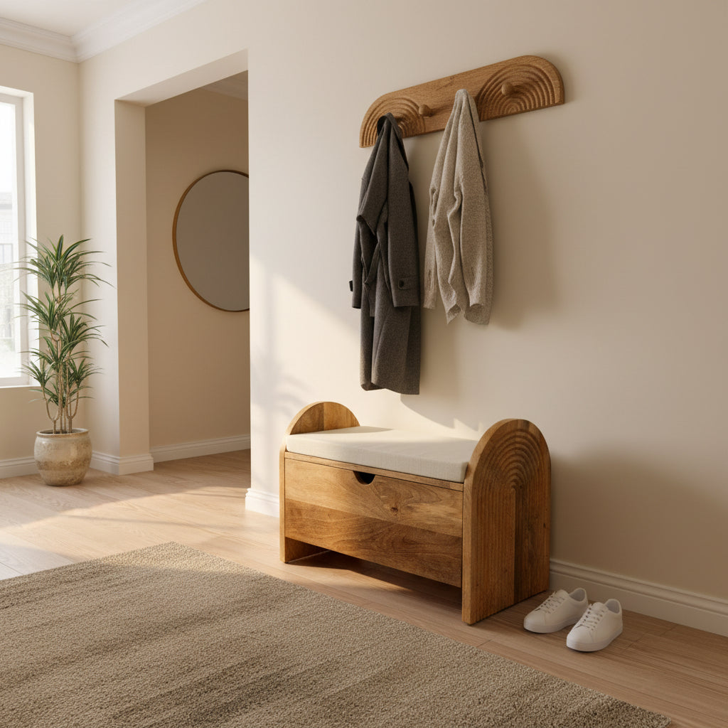 A rustic wooden storage bench with a cream cushion, featuring arched ends with concentric circle details and a drawer on the front, resting on a white sheet in a workshop.