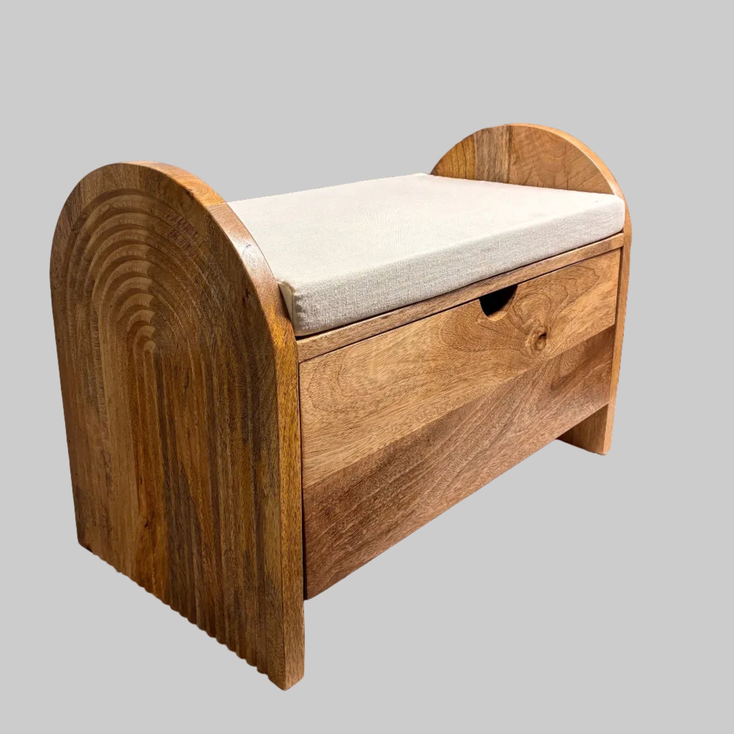 A wooden storage bench or chest with a curved backrest, featuring a light beige cushion on top and a single front drawer, photographed in a workshop or furniture setting.