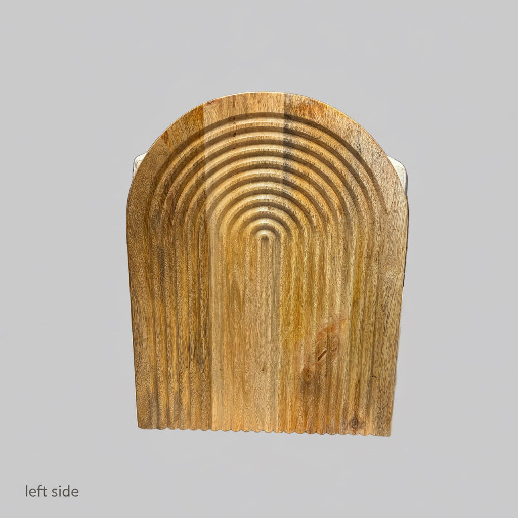 A rustic wooden board with a carved concentric arch pattern, displayed on a white sheet in a workshop or warehouse setting.