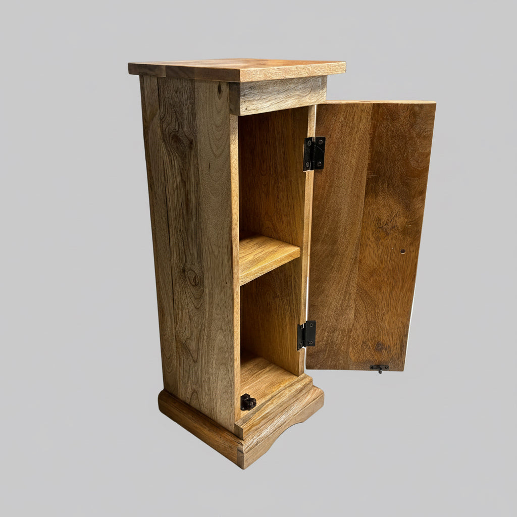 A rustic wooden cabinet with a single open door, showing two interior shelves, photographed on a white surface against a gray wall and wooden shelving in the background.