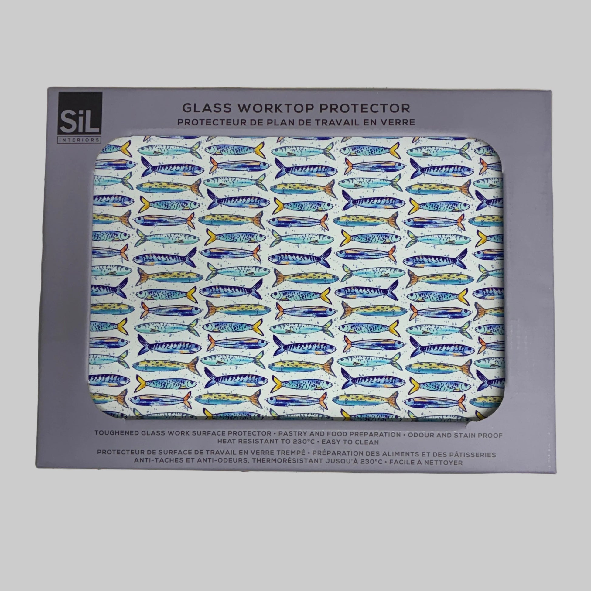 A boxed glass worktop protector with a visible window showing a repeating fish pattern in blue, yellow, and white. The package is placed on a light beige stone-like surface.