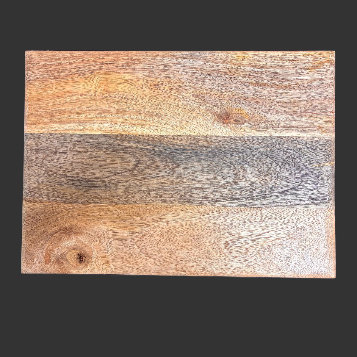 A rectangular wooden board or plank sample with a natural wood grain pattern, featuring light brown, tan, and dark gray tones, shown against a solid dark gray background.