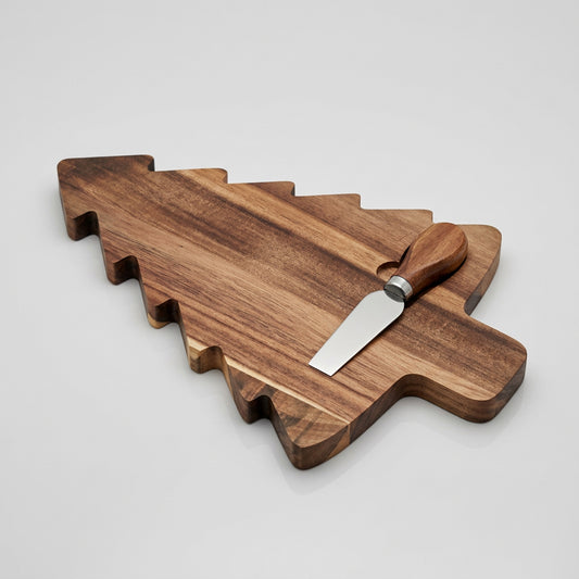 A dark brown wooden cheese board with a matching wooden spatula resting on top, photographed on a rustic wood surface.