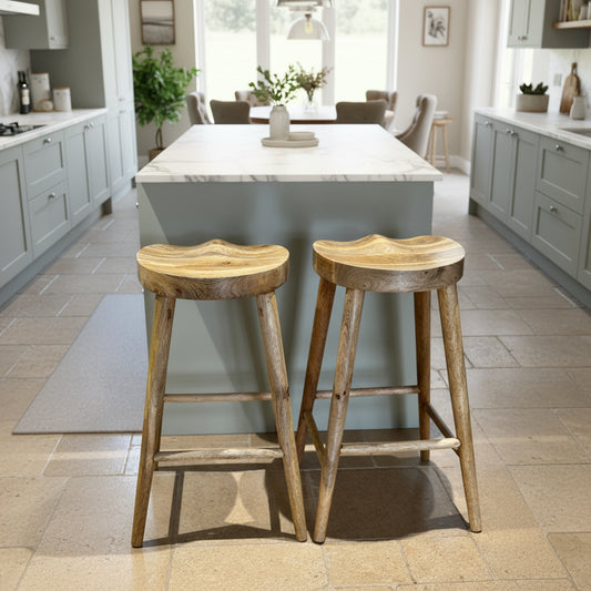 Pair of Mango wood bar stools with scalloped seat in a kitchen