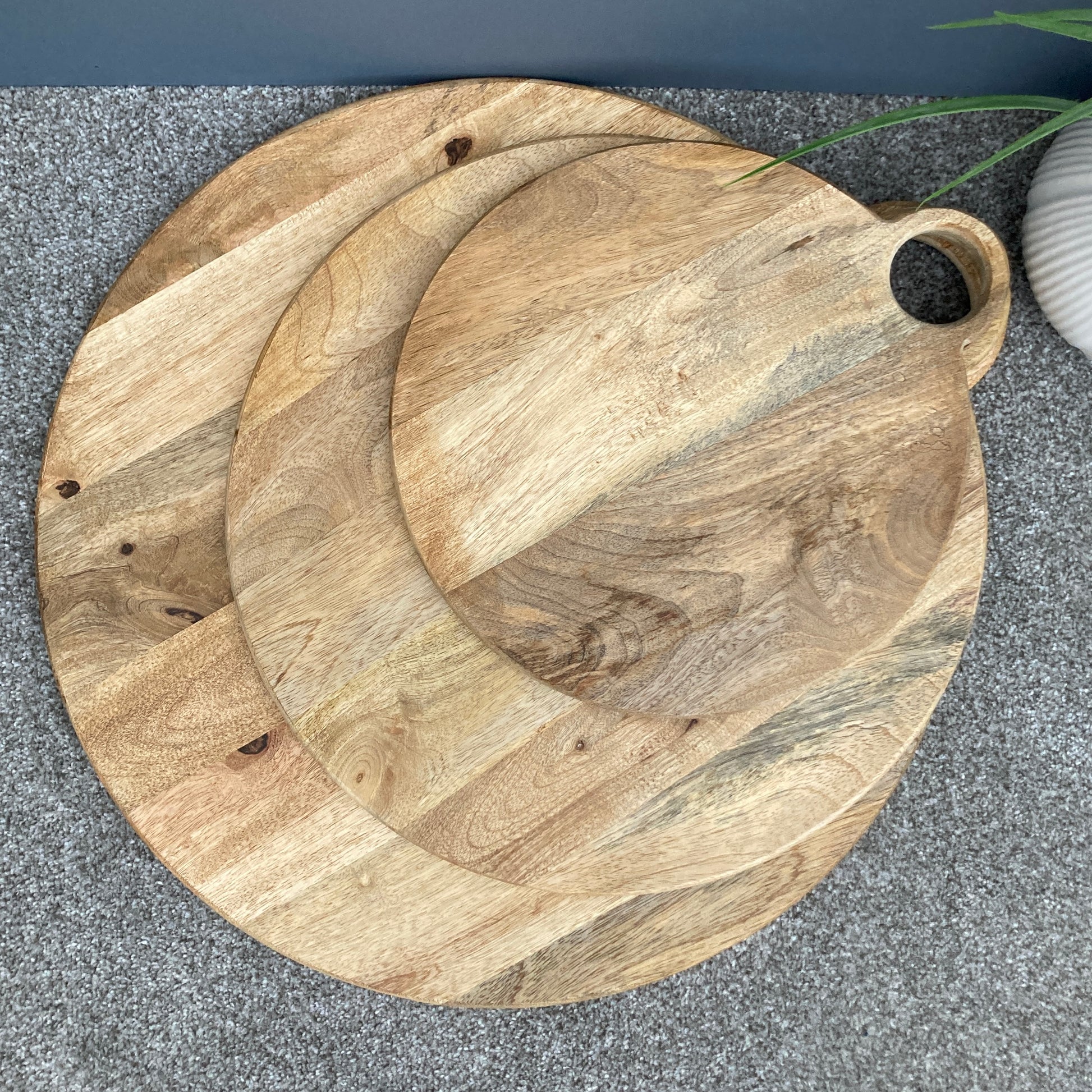 Round loop handled food boards made from solid Mango wood. looking from above.