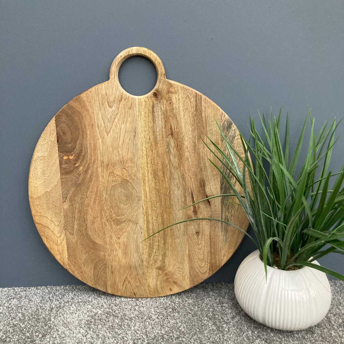 Round loop handled food boards made from solid Mango wood. Stood up on a counter