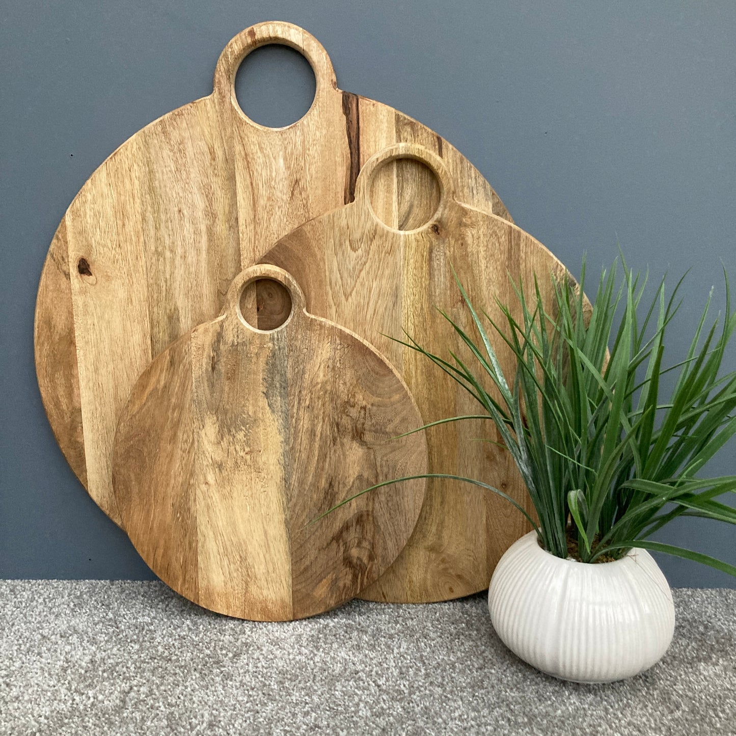 Round loop handled food boards made from solid Mango wood. Close shot of 3