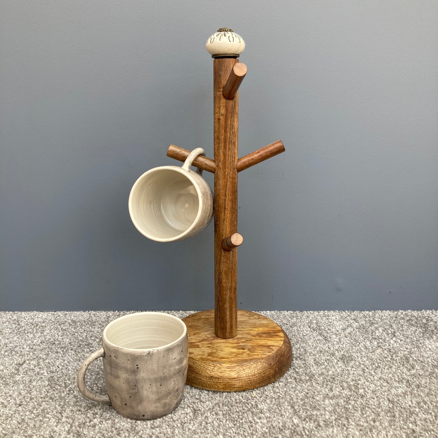 Dark Mango wood mug tree to hold up to 6 cups. 2 designs. One design shown with mugs
