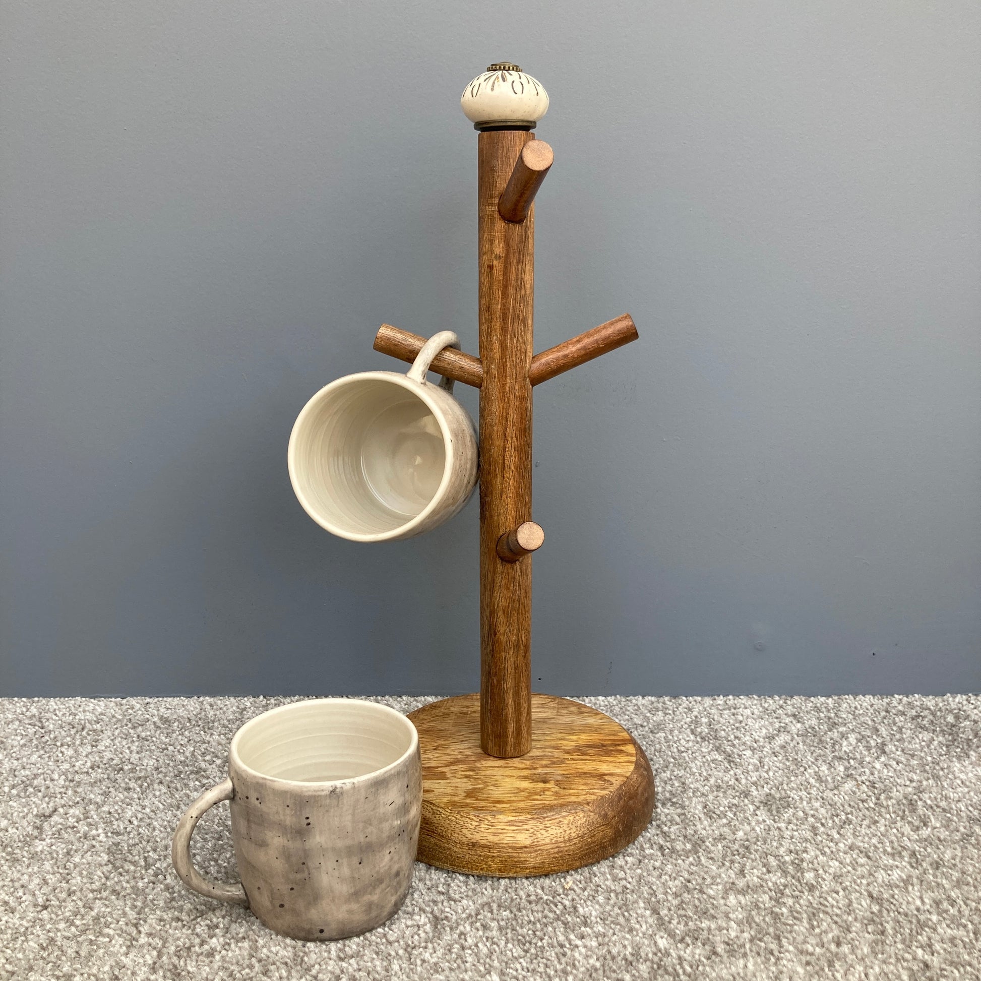 Dark Mango wood mug tree to hold up to 6 cups. 2 designs. One design shown with mugs