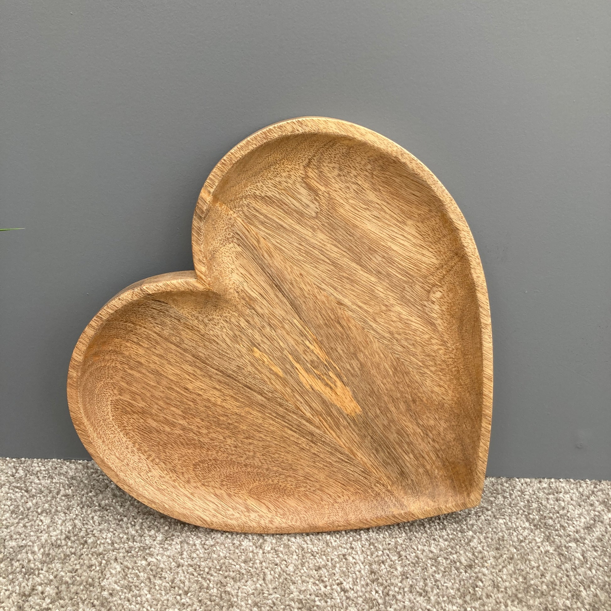 Hand carved solid Mango wood wooden heart dish / board on a counter