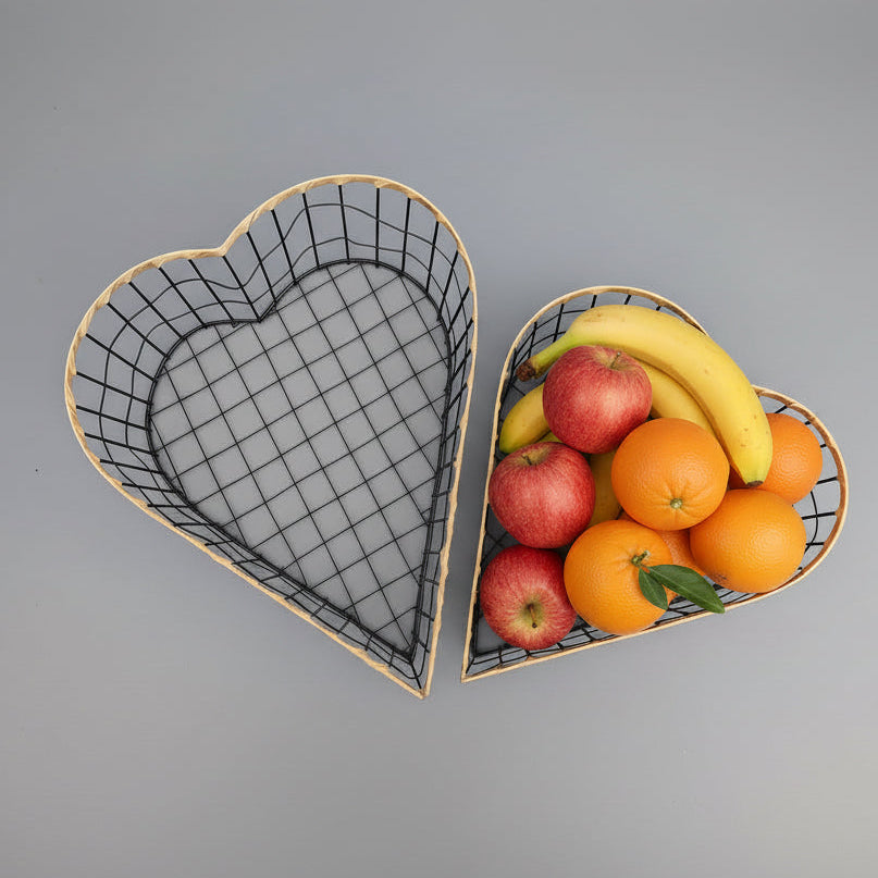 Heart-shaped wire baskets with fruits on a gray background