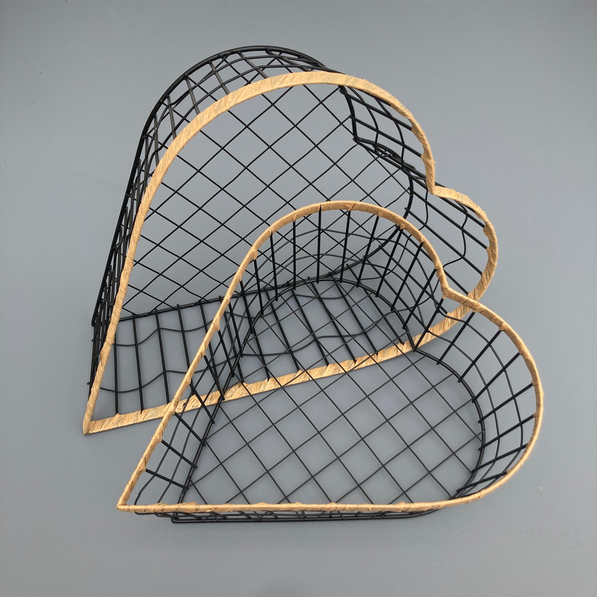 Heart shaped woven metal fruit baskets with raffia edging. View from above hearts.