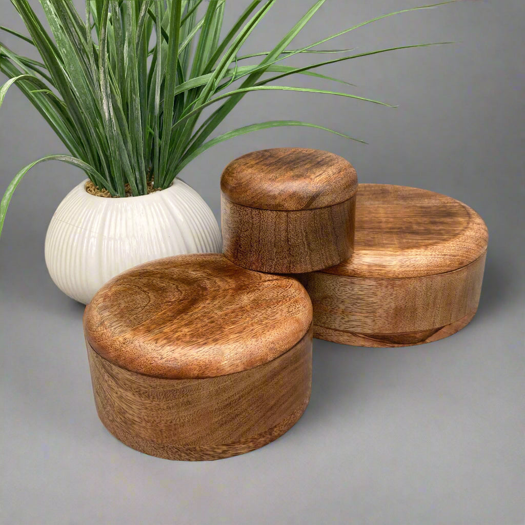Dark Mango wood round lidded boxes. 3 boxes displayed.