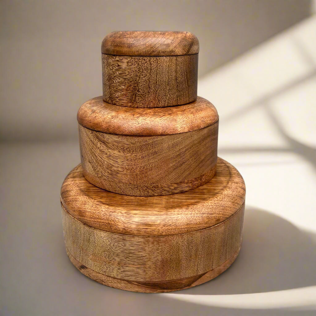 Dark Mango wood round lidded boxes. 3 boxes stacked.