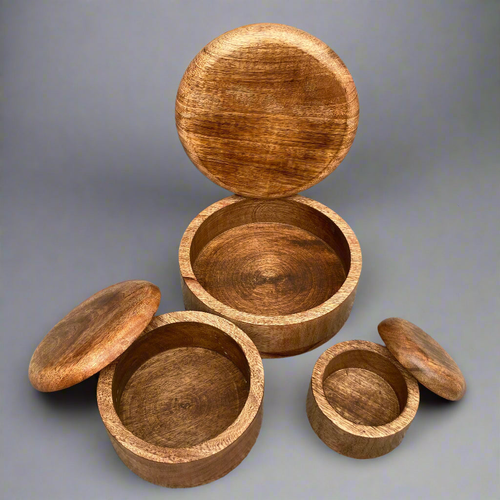 Dark Mango wood round lidded boxes. All boxes open.