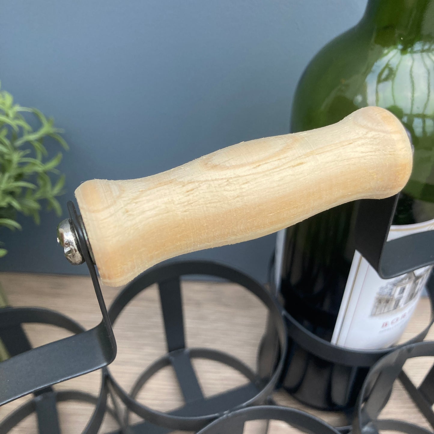 Black steel 6 bottle holder. Ideal for milk basket, wine rack, or condiments. Close up of handle.
