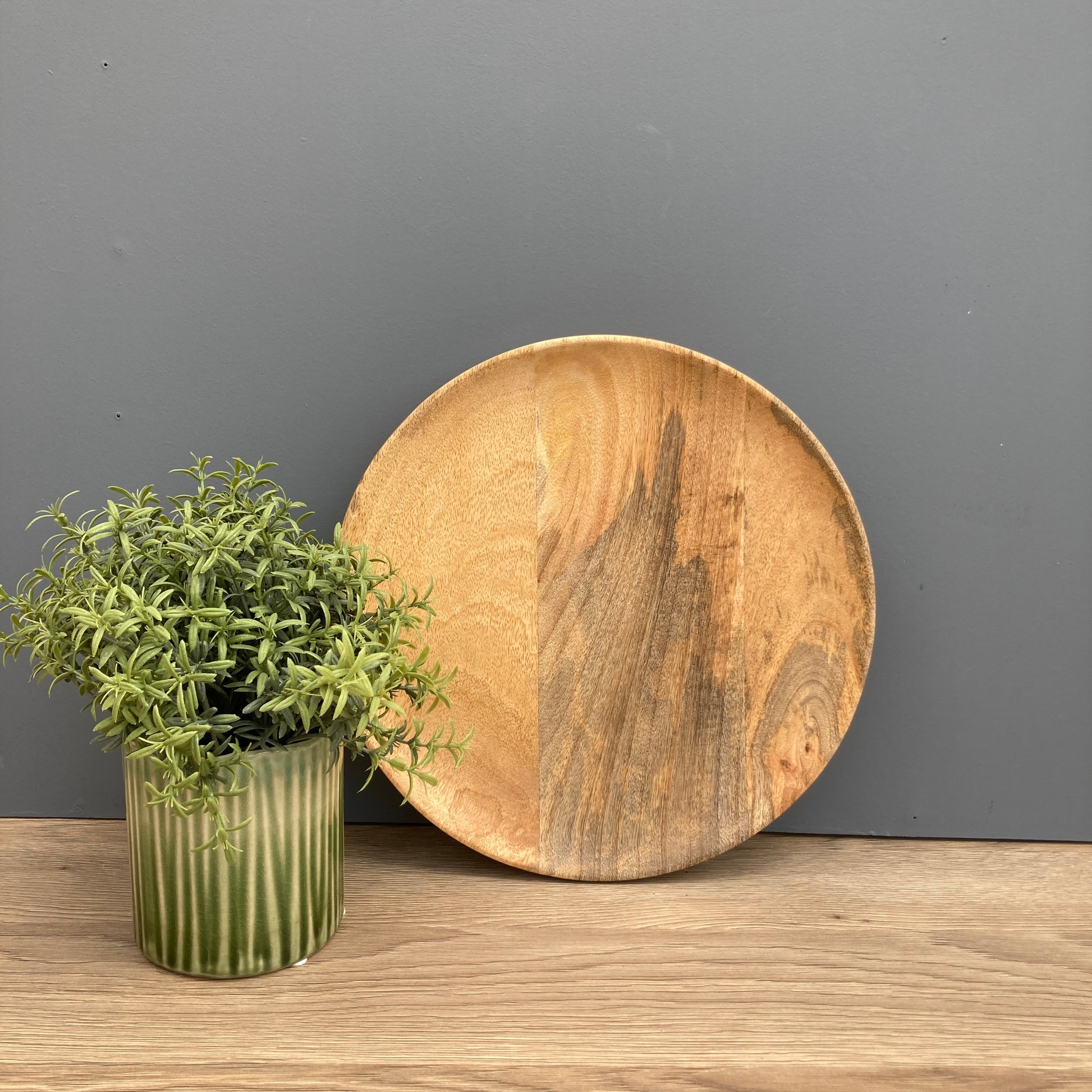 30cm Solid Mango plate on a counter with a green pot