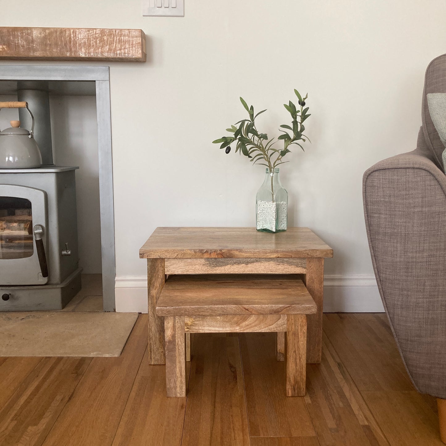Pair of square finish Mango wood coffee tables from the front in a room setting