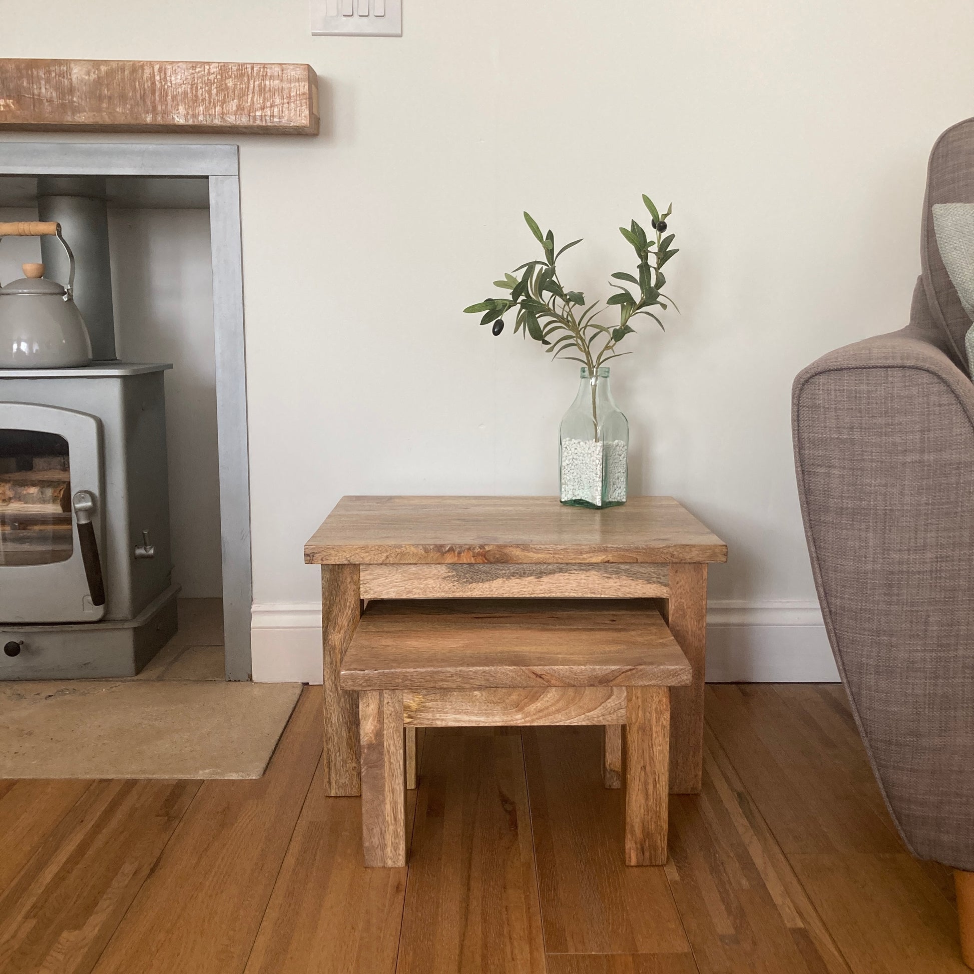 Pair of square finish Mango wood coffee tables from the front in a room setting