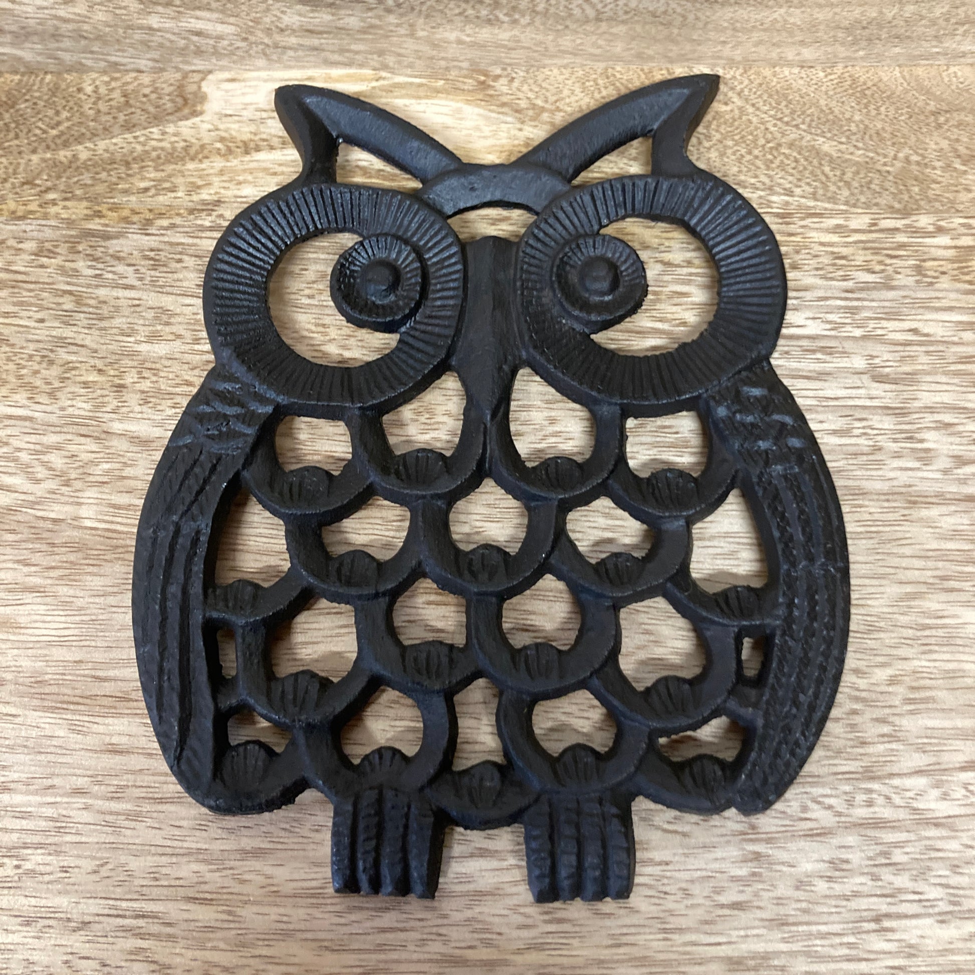 Black painted cast iron OWL design trivet / hotplate - on table