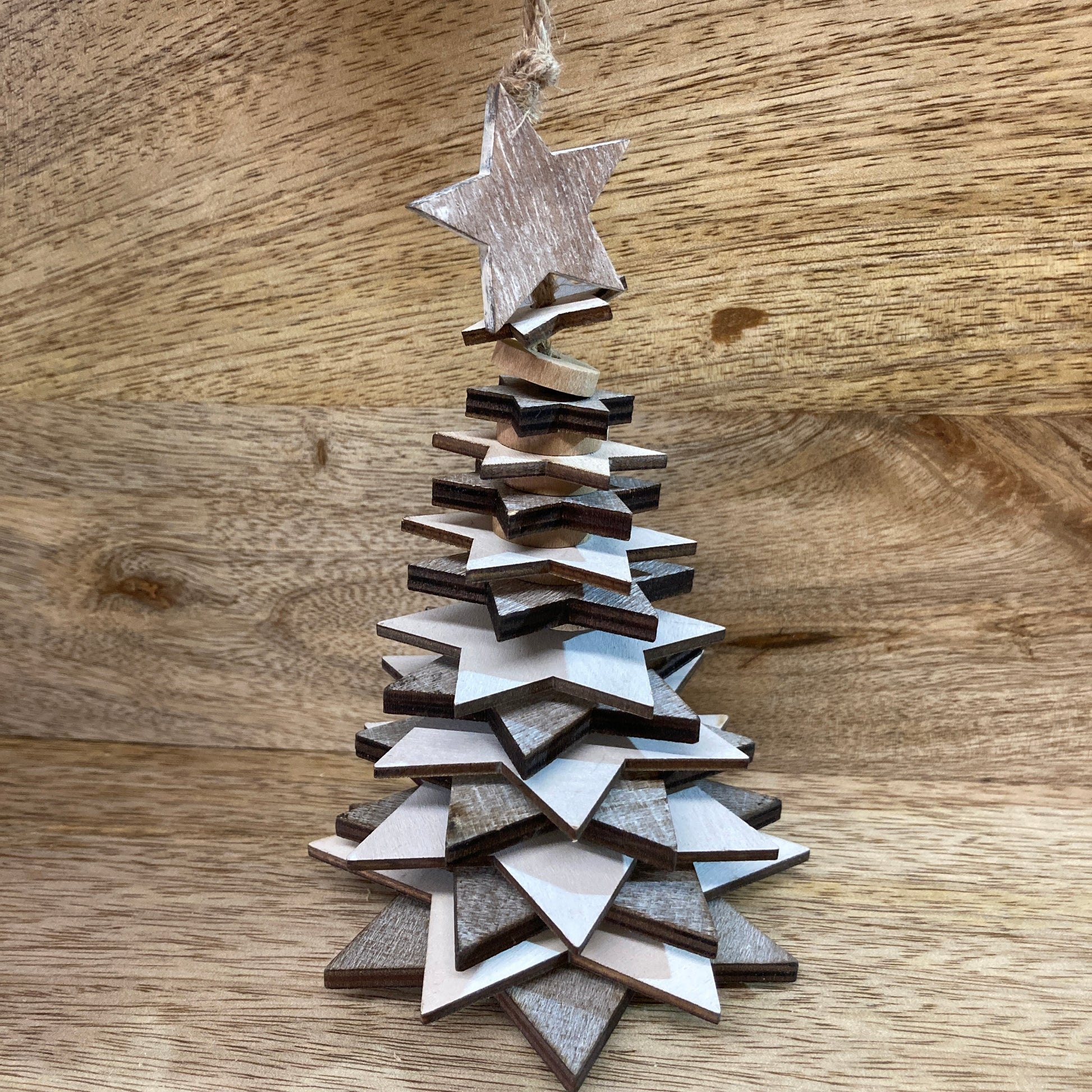 Wooden star Christmas trees - hanging above table. 