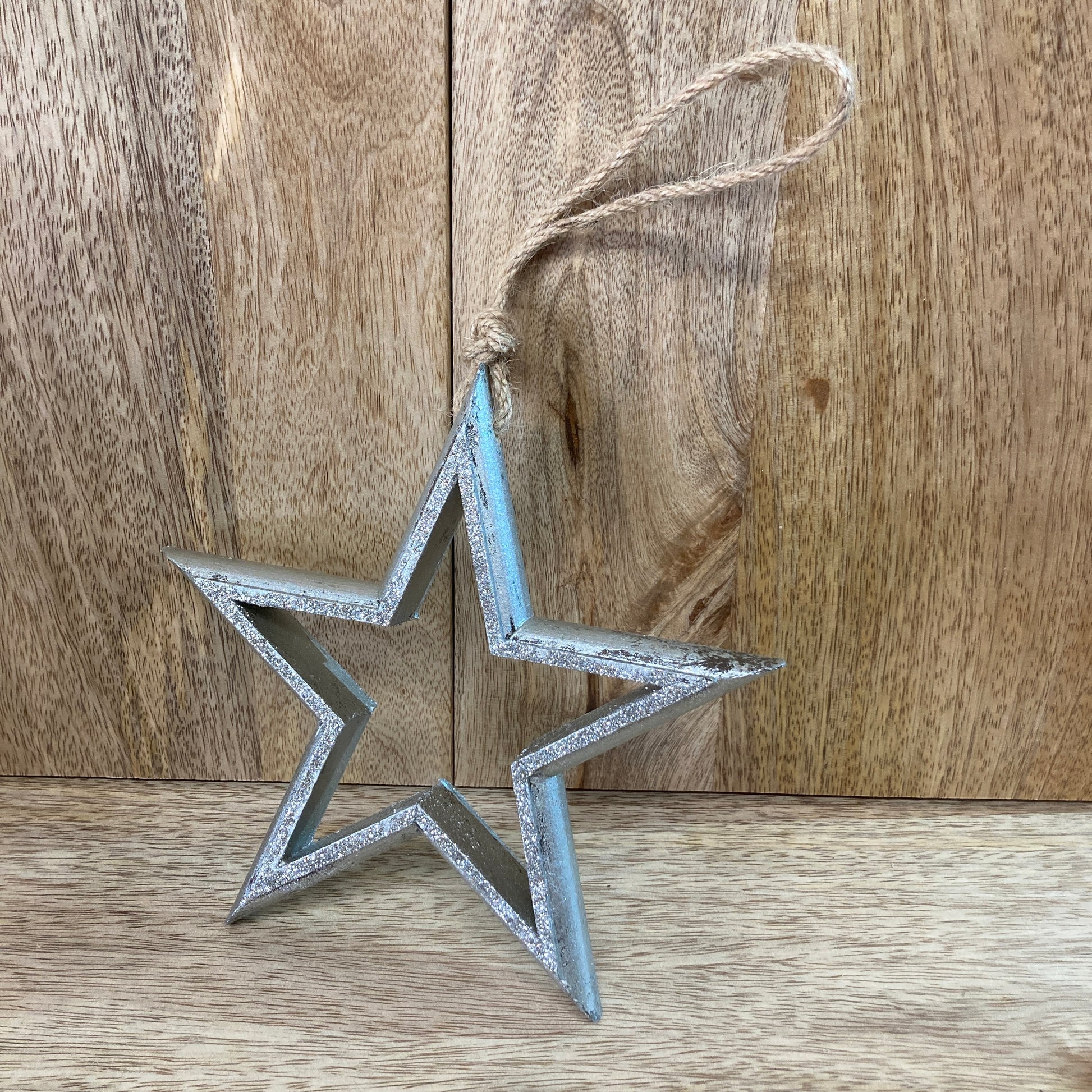 Hanging wooden star - resting against wood
