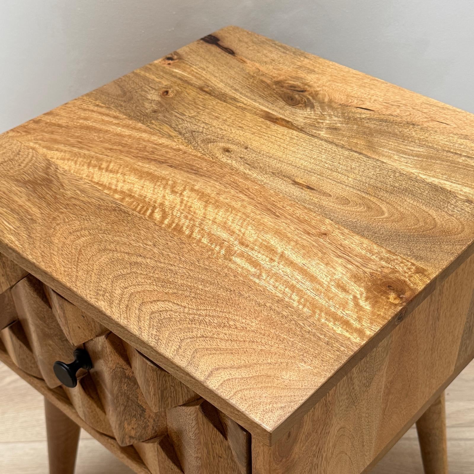 Wooden side table with a single drawer on a neutral background