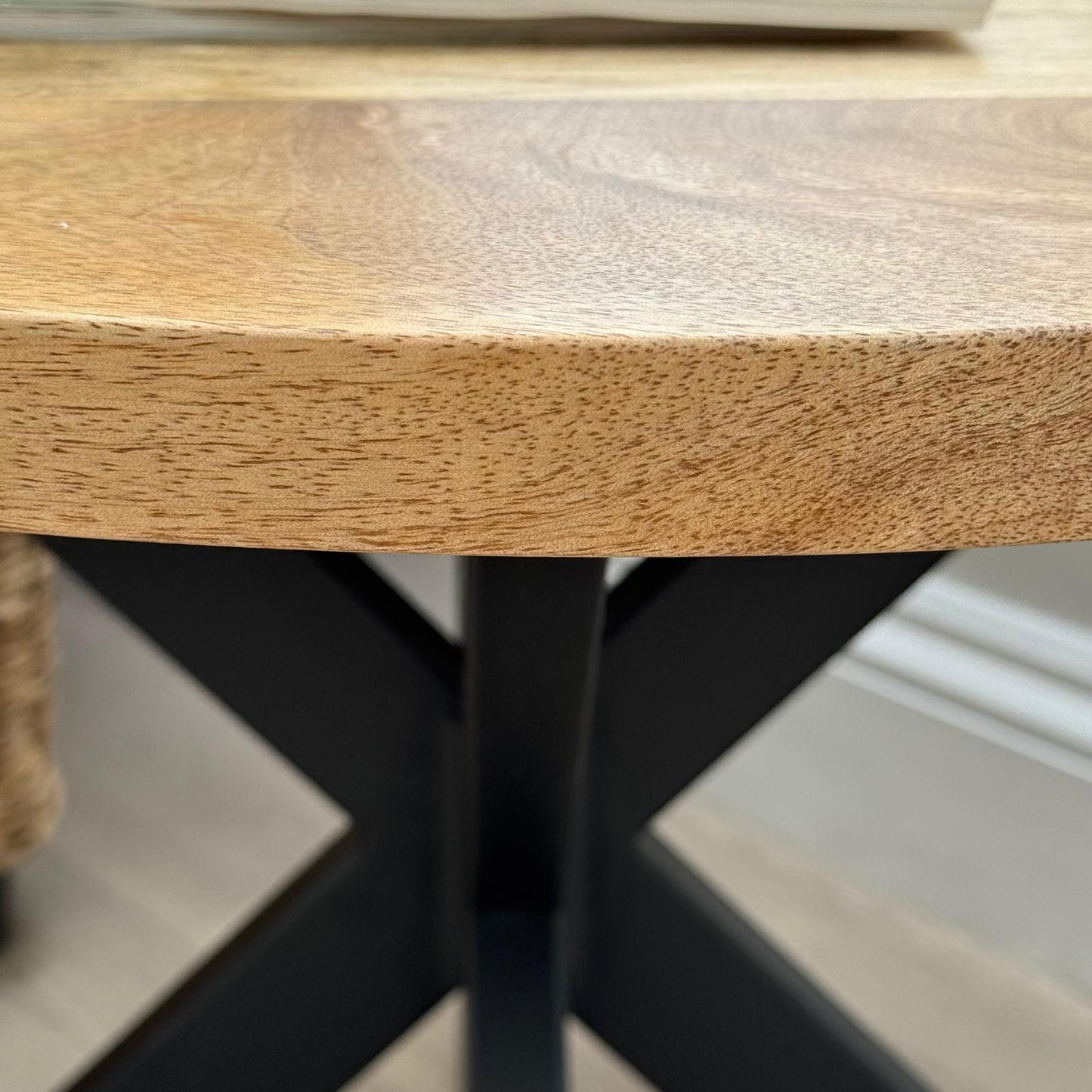60cm round Mango wood top coffee table with black metal legs. Close up of table top. 