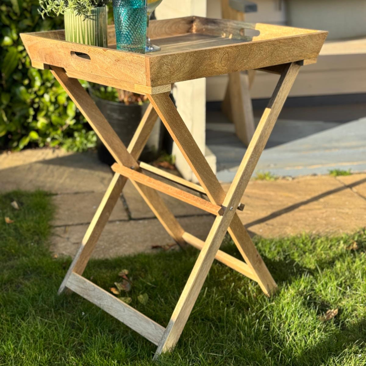 Sloping edge butler tray on foldable stand - Mango wood. Focusing on base.