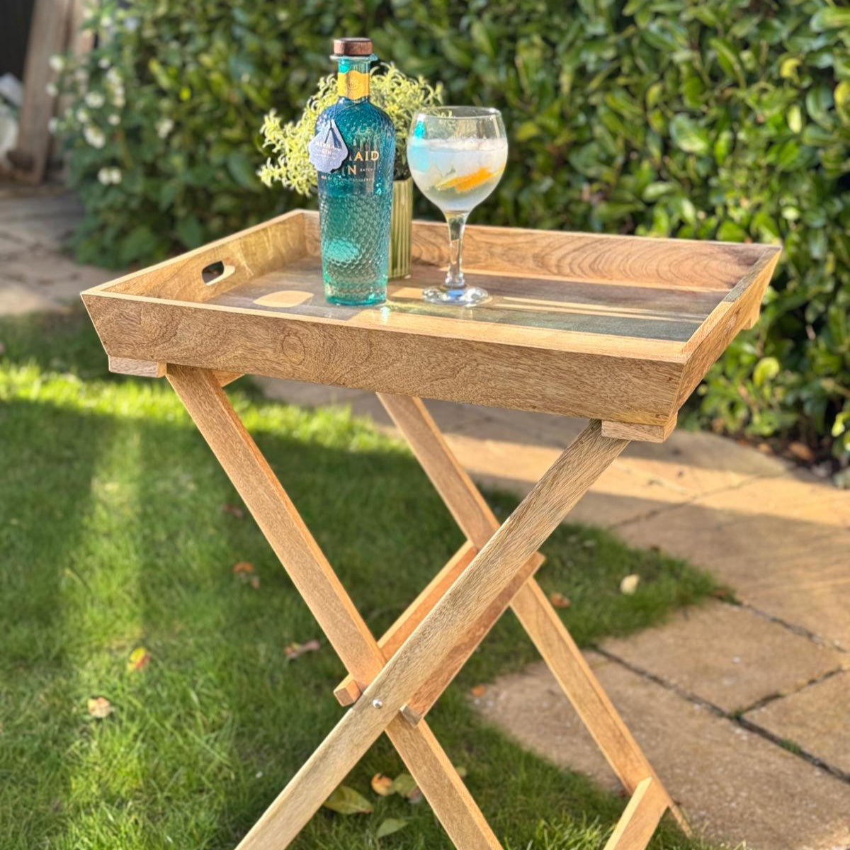 Sloping edge butler tray on foldable stand - Mango wood. Shown with G&T