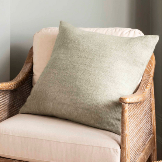 Large 60cm Herringbone wool cushion - Sage - on chair.