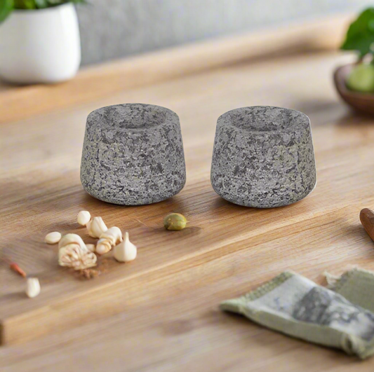Two grey stone candle holders on a white background