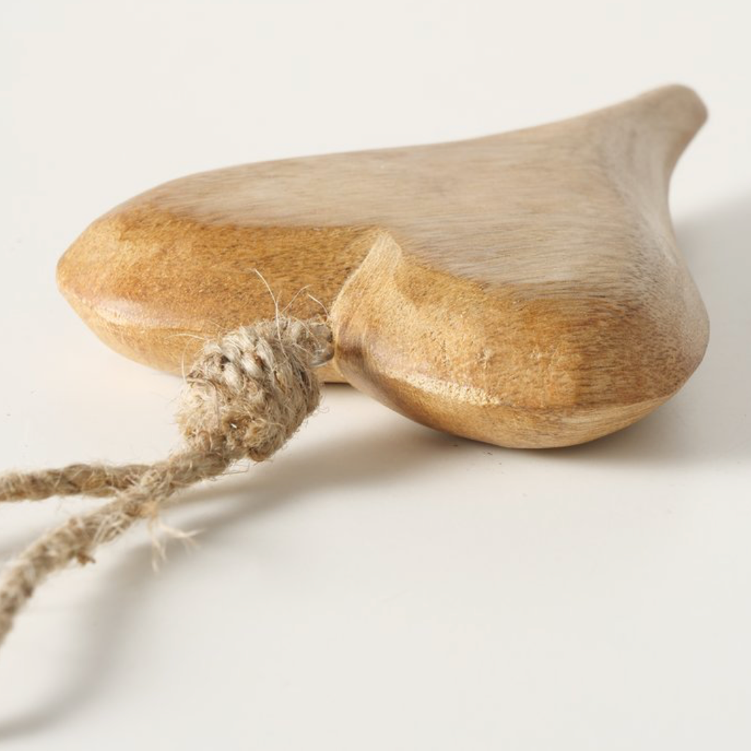 Wooden object with a rope tied around it on a light background