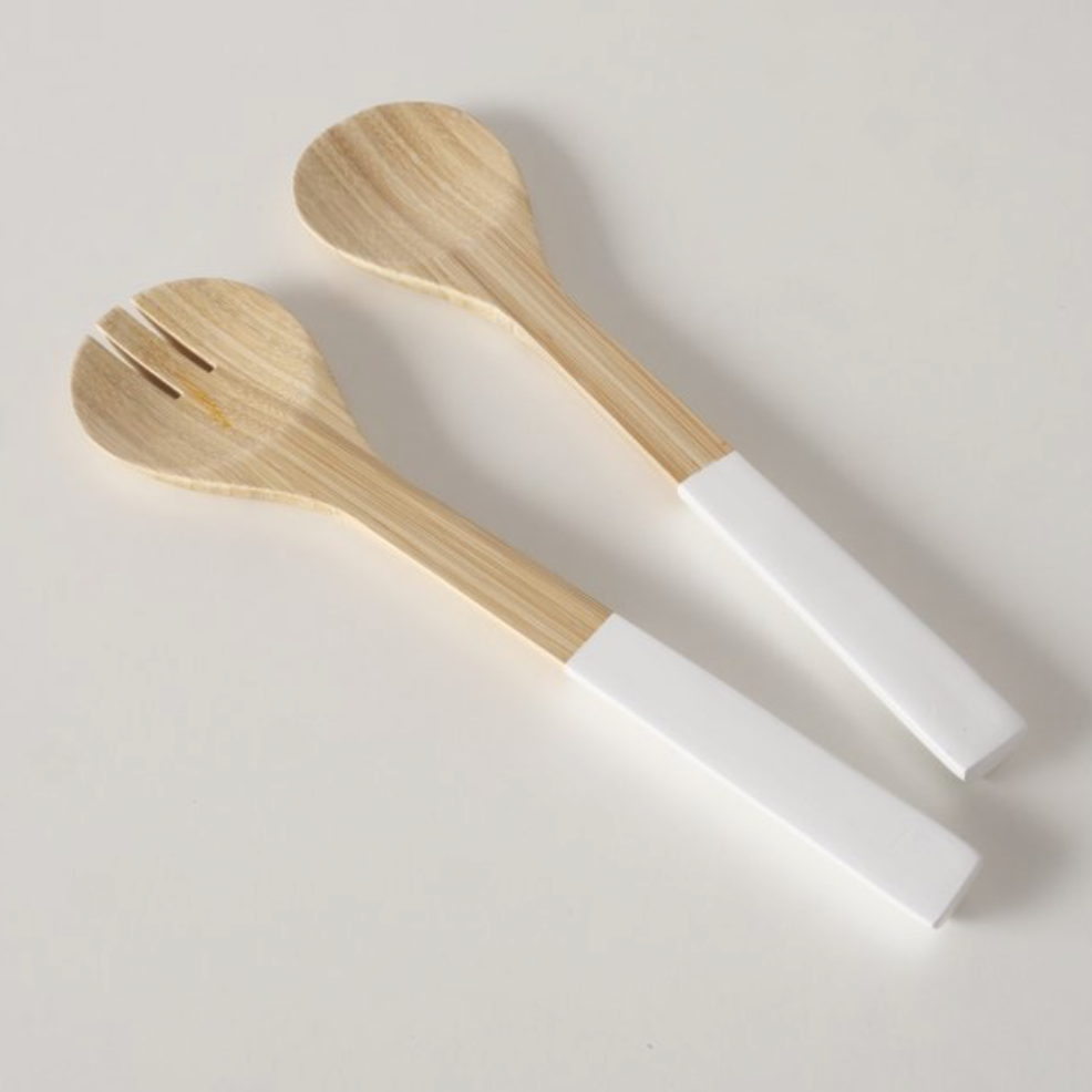 Two wooden spoons with white handles on a light gray background