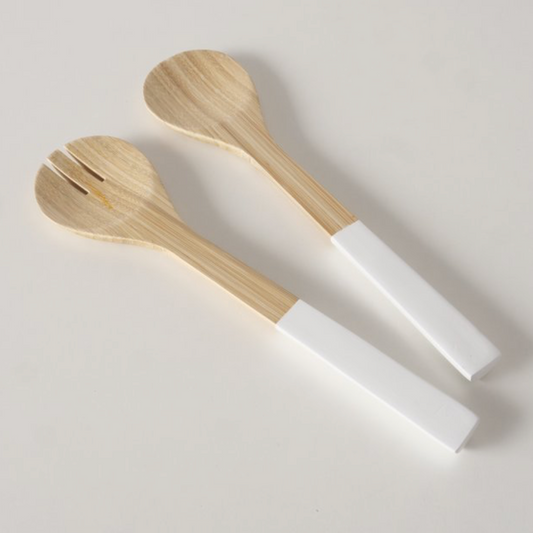 Two wooden spoons with white handles on a light gray background
