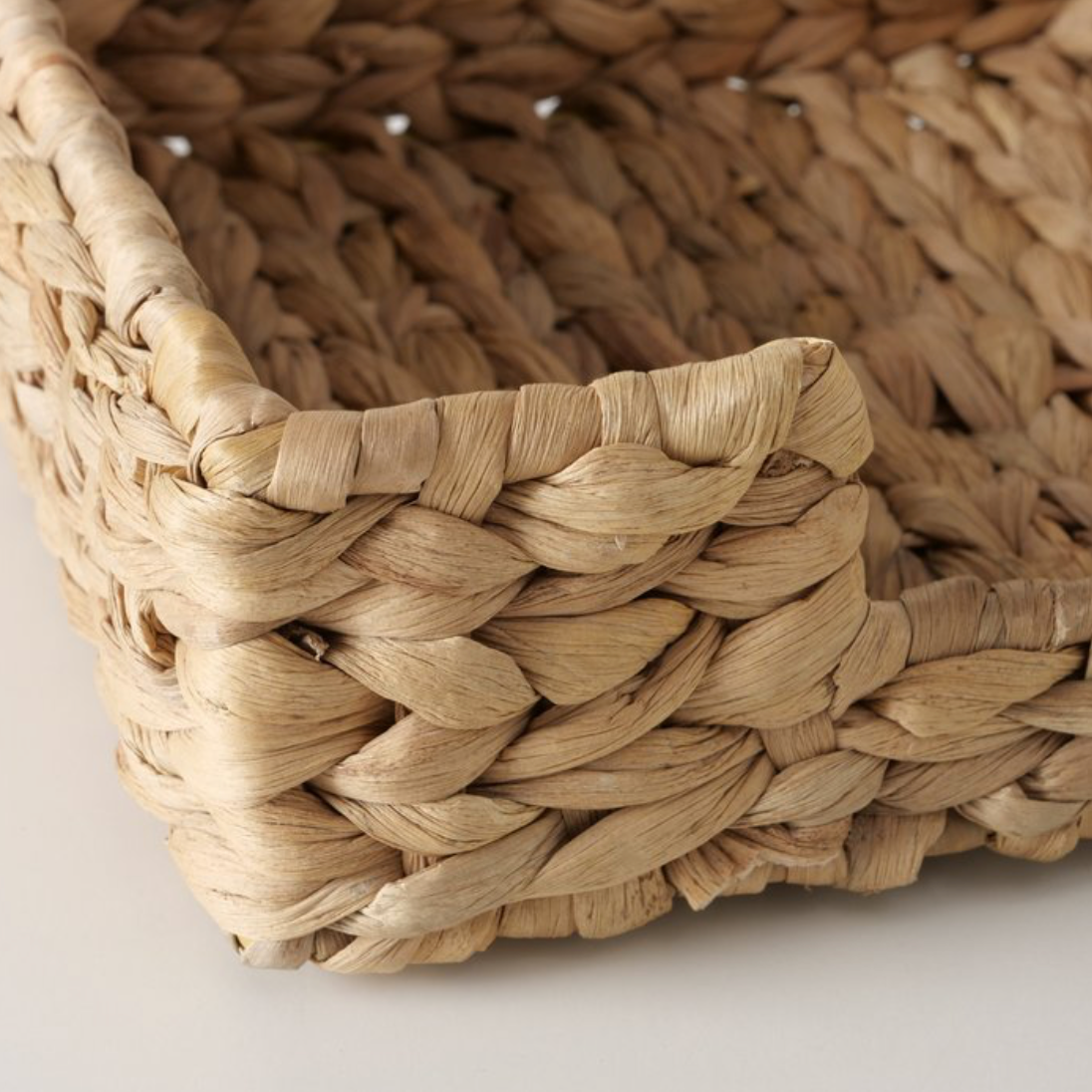 Close-up of a woven basket with natural brown tones on a light background