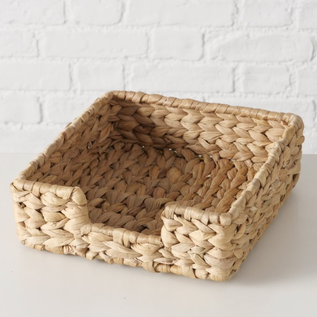 Woven basket on a white surface with a white brick wall background