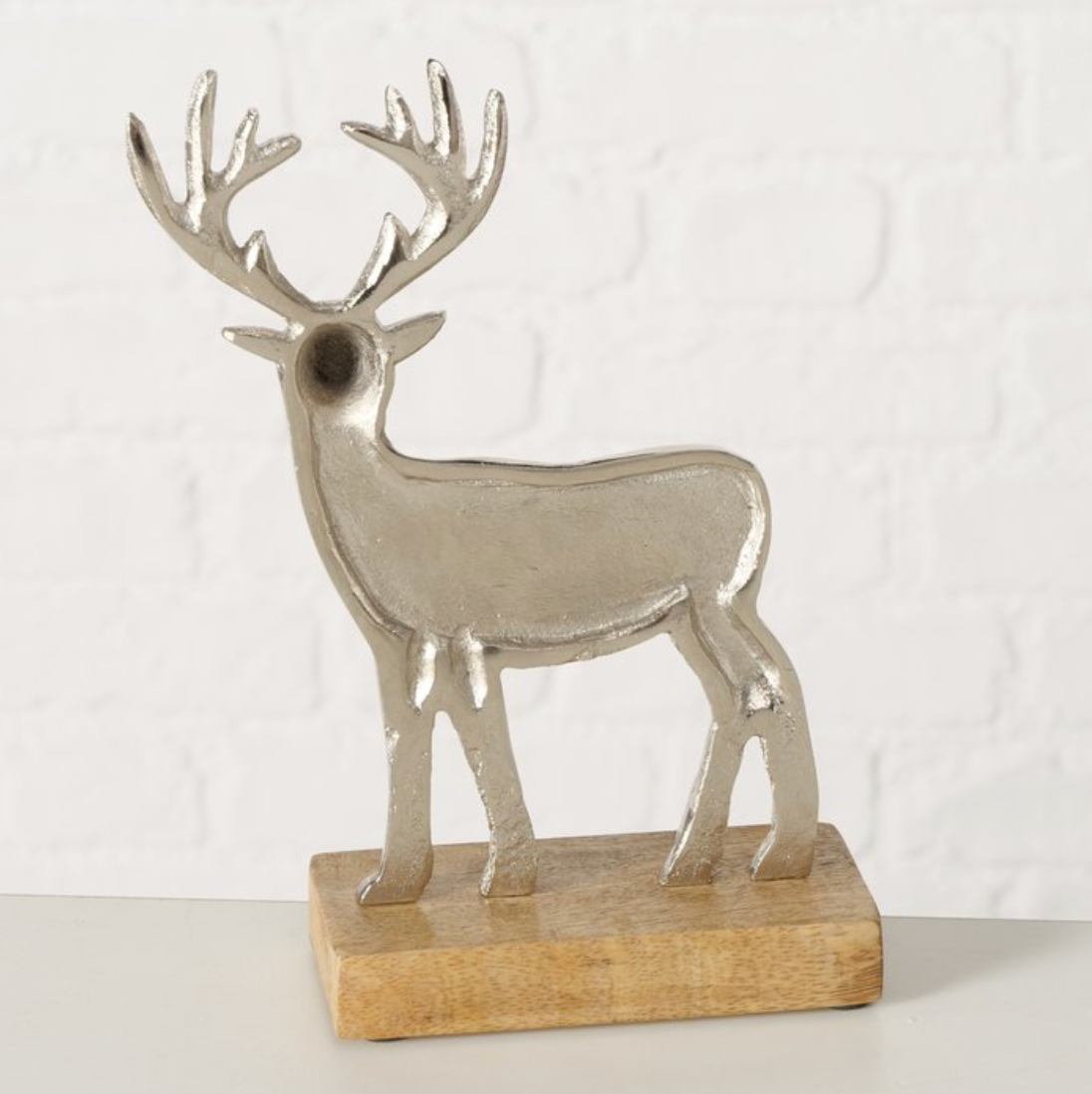 Decorative deer figure on a wooden base with a plain background