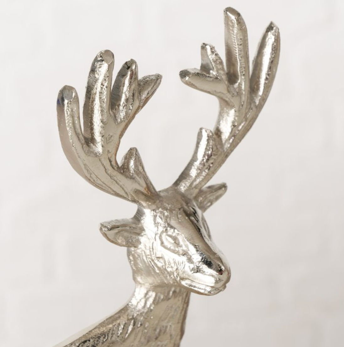 Silver deer head ornament on a white background