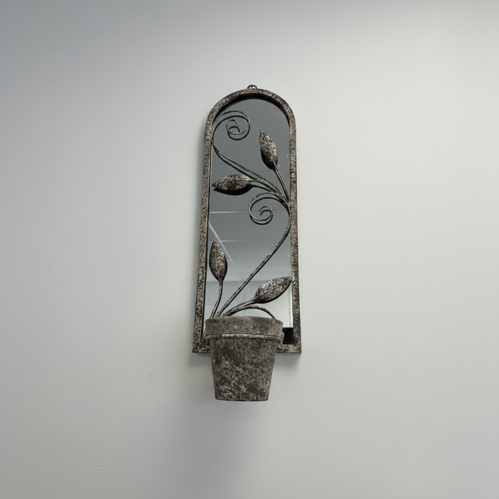 Decorative wall mirror with plant design on a plain wall
